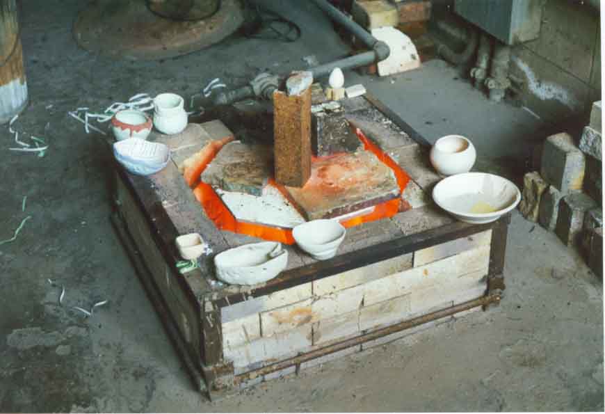 Ready for a second firing, the pottery is slowing being warmed to prevent breakage